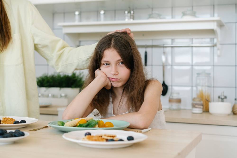 Criança recusando comida à mesa